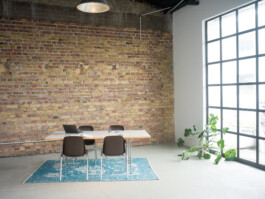 Schreibtisch mit Fensterfront und Backsteinwand