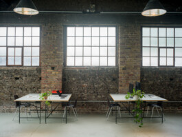Coworking Bereich mit Schreibtischen und Stahlsprossenfenstern